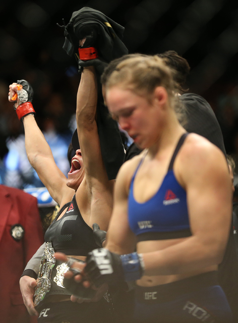 Amanda Nunes, left, celebrates after defeating Ronda Rousey by TKO in the first round during their bantamweight championship fight at UFC 207 at T-Mobile Arena on Friday, Dec. 30, 2016, in Las Veg ...