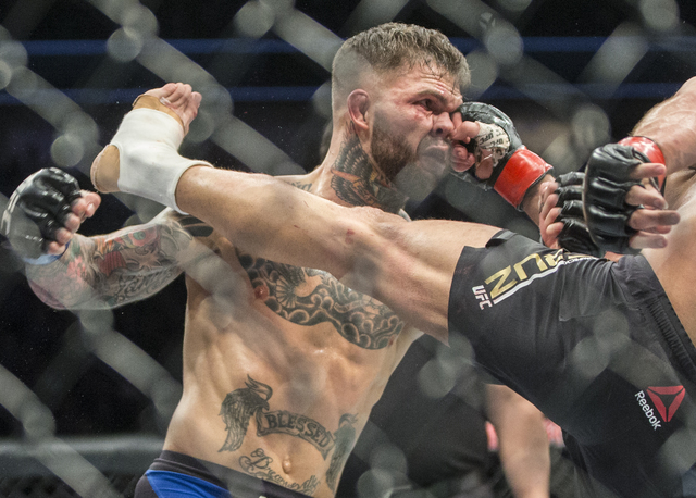 Cody Garbrandt, left, takes a punch with landing a strike against Dominick Cruz during their bantamweight fight at UFC 207 at T-Mobile Arena on Friday, Dec. 30, 2016, in Las Vegas. Benjamin Hager/ ...