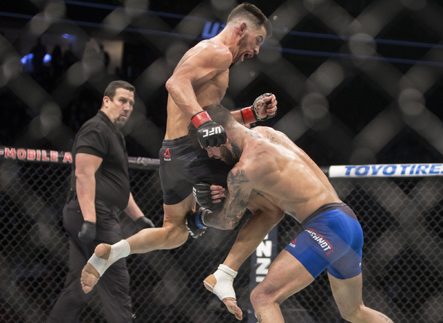 Dominick Cruz, left, lands a flying knee against Cody Garbrandt during their bantamweight fight at UFC 207 at T-Mobile Arena on Friday, Dec. 30, 2016, in Las Vegas. Benjamin Hager/Las Vegas Review ...