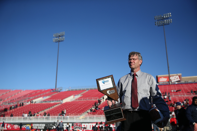 Bart Thompson, executive director for the Nevada Interscholastic Activities Association, gets ready to present the champion trophy to Bishop Gorman after their 84-8 win against Liberty in the Clas ...