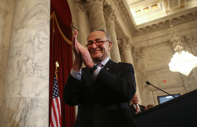 Incoming Senate Minority Leader Sen. Charles Schumer, D-N.Y., claps during a ceremony to unveil a portrait of Senate Minority Leader Harry Reid, D-Nev., on Capitol Hill in Washington D.C. on Thurs ...