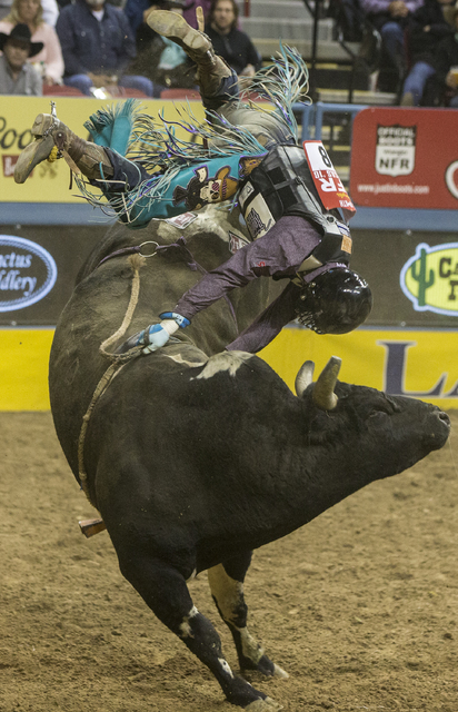 Garrett Smith is thrown from Spotted Demon during the bull riding competition on the ninth day of the National Finals Rodeo at the Thomas & Mack Center on Friday, Dec. 9, 2016, in Las Vegas. B ...