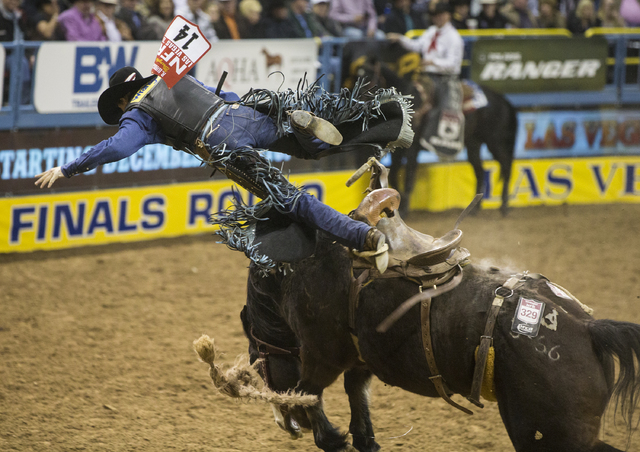 Rusty Wright is thrown from Stampede Warrior during the saddle bronc riding competition on the ninth day of the National Finals Rodeo at the Thomas & Mack Center on Friday, Dec. 9, 2016, in La ...