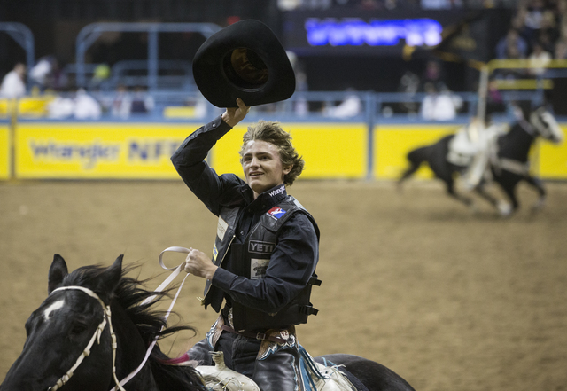Ryder Wright salutes the crowd after winning the saddle bronc riding competition on the ninth day of the National Finals Rodeo at the Thomas & Mack Center on Friday, Dec. 9, 2016, in Las Vegas ...