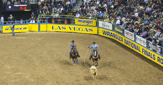 Junior Nogueira, left, and Kaleb Driggers compete during the team roping competition on the final night of the National Finals Rodeo at the Thomas & Mack Center in Las Vegas on Saturday, Dec.  ...