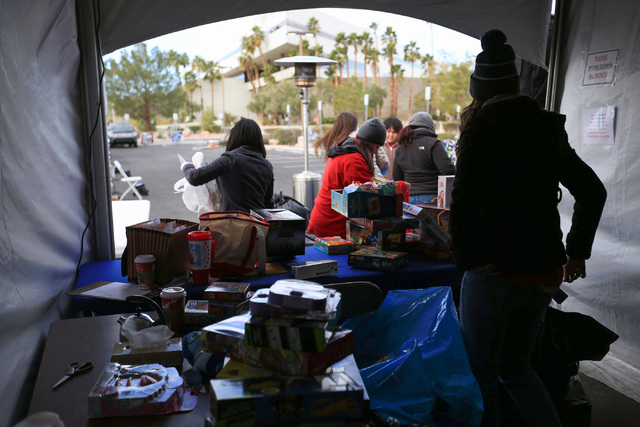 Volunteers from The Venetian hotel-casino sort bags full of donated toys at the 18th annual KLUC Toy Drive on Friday, Dec. 2, 2016, where Chet Buchanan, host of 98.5 KLUC's Chet Buchanan and the M ...