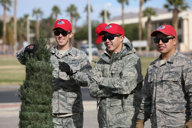 Airman Shea Ogburn, left, Senior Airman Jeremy Berndt and Senior Airman Mark Schoel help pass out Christmas trees to Enlisted airmen and their families at Nellis Air Force Base as part of the annu ...