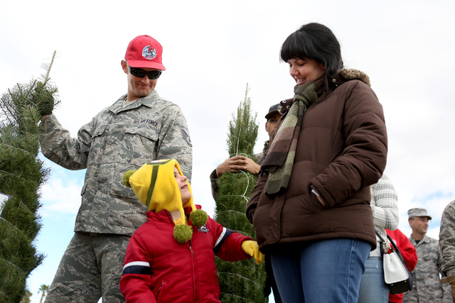 Staff Sgt. Richard West, left, and Elissa Ryan with her son Seth pickup a Christmas tree at Nellis Air Force Base as part of the annual Christmas SPIRIT Foundation’s Trees for Troops Progra ...
