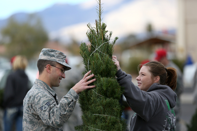 Senior Airman Adam Low and wife Bethany decide on a Christmas tree during the annual Christmas SPIRIT Foundation’s Trees for Troops Program at Nellis Air Force Base on Friday, December 2, ...