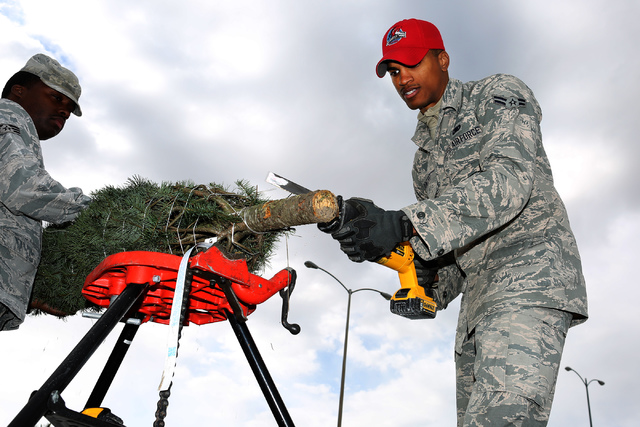 Airman First Class Sterling Benford, right, puts fresh cut a Christmas tree as part of the annual Christmas SPIRIT Foundation’s Trees for Troops Program at Nellis Air Force Base on Friday,  ...