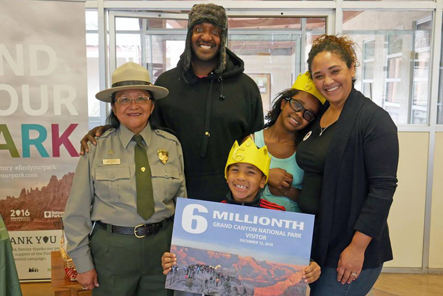 Las Vegas couple James and Abigail Johnson and their children, Sophia and Elijah, pose Monday with a National Park Service employee after being named the record 6th million visitors to Grand Canyo ...