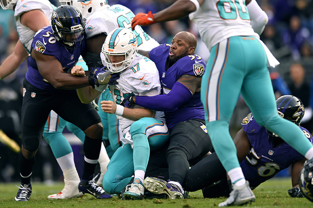Baltimore Ravens outside linebacker Terrell Suggs (55) tackles Miami Dolphins quarterback Ryan Tannehill after his helmet fell off in the second half of an NFL football game, Sunday, Dec. 4, 2016, ...