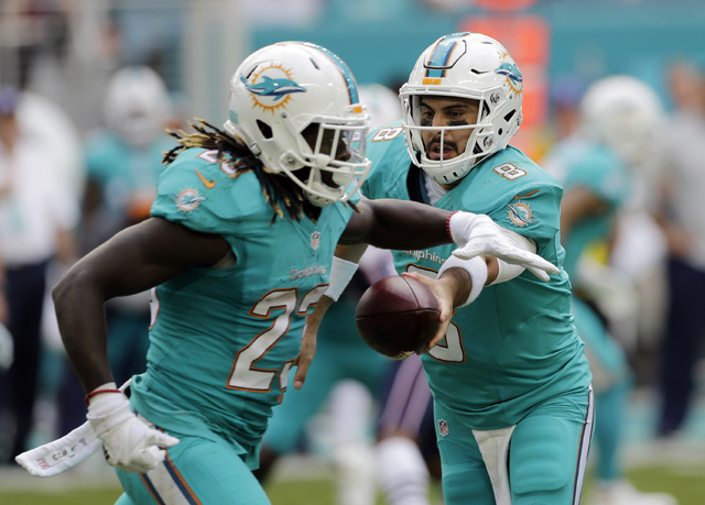 Miami Dolphins quarterback Matt Moore (8) hands the ball to running back Jay Ajayi (23), during the first half of an NFL football game against the New England Patriots, Sunday, Jan. 1, 2017, in Mi ...
