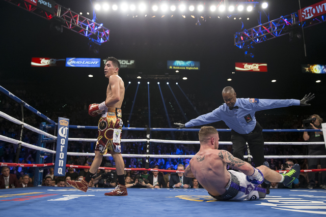 Carl Frampton, right, slips to the ground in his fight against Leo Santa Cruz in the WBA Featherweight Championship bout at MGM Grand Garden Arena on Saturday, Jan. 28, 2017, in Las Vegas. Santa C ...
