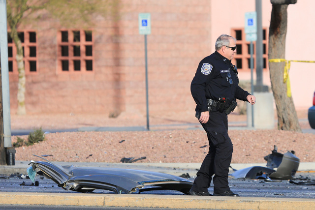 A North Las Vegas police officer walks past the roof of a Ford Taurus that was cut off at the scene of a crash on Martin Luther King Boulevard near Carey Avenue on Friday, Jan. 6, 2017. Brett Le B ...