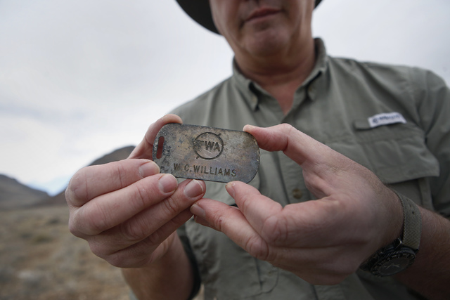 FAA accident investigator Mike McComb, 50, holds a crew baggage tag which was the property of Wayne C. Williams, who was the pilot in command during the 1942 DC-3 crash that killed actress Carole  ...