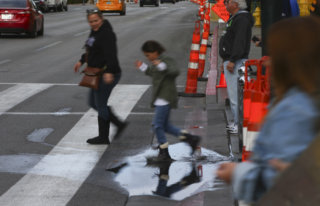 A girl splashes in a puddle along Fremont Street at Las Vegas Boulevard in downtown on Friday, Jan. 13, 2017. (Chase Stevens/Las Vegas Review-Journal) @csstevensphoto