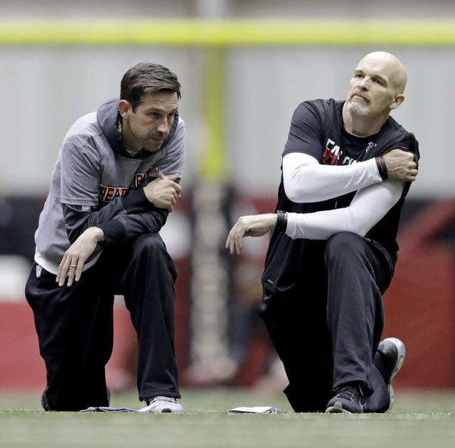Atlanta Falcons head coach Dan Quinn, right, talks with offensive coordinator Kyle Shanahan during a workout at the NFL football team's practice facility in Flowery Branch, Ga., Friday, Jan. 27, 2 ...