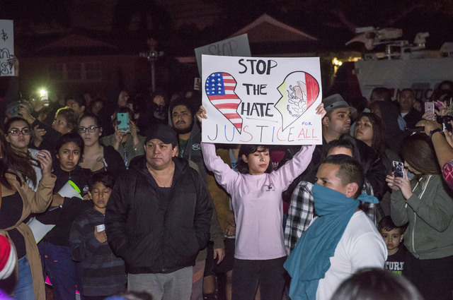 Protesters hold signs in front of an Los Angeles Police Department officer's home in Anaheim, California, Wednesday, Feb. 22, 2017. A Los Angeles policeman is under investigation after a video app ...