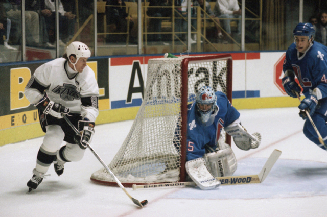 Los Angeles Kings center Wayne Gretzky, left, maneuvers the puck as Quebec  Nordiques goalie Stephane Fiset covers the goal in the first period of  Tuesday's NHL game at the Forum in Inglewood