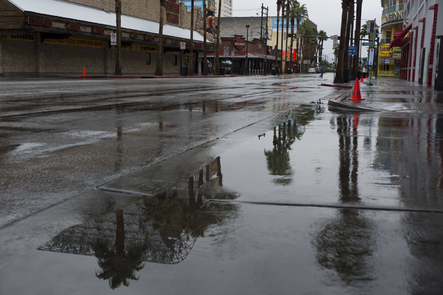 Puddles fill the street on Saturday, Feb. 18, 2017, in downtown Las Vegas. On Friday a flash-flood watch for Southern Nevada that will last through Saturday evening was issued by weather service . ...