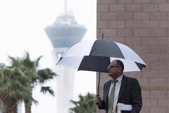 A pedestrian walks in the rain along Lewis Avenue near the Regional Justice Center on Friday, Jan. 20, 2017, in Las Vegas. (Bizuayehu Tesfaye/Las Vegas Review-Journal) @bizutesfaye