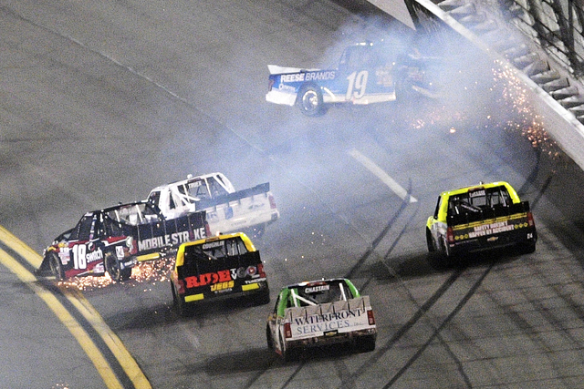 Austin Cindric (19) hits the wall as Noah Gragson (18) and Ryan Truex (16) collide in a multi-vehicle crash in Turn 1 during the NASCAR Trucks auto race at Daytona International Speedway, Friday, ...