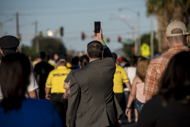 A man holds up his cell phone during the Peace Walk held at the Las Vegas Police Department Convention Center Area Command in Las Vegas on Thursday, June 11, 2015. (Joshua Dahl/Las Vegas Review-Jo ...