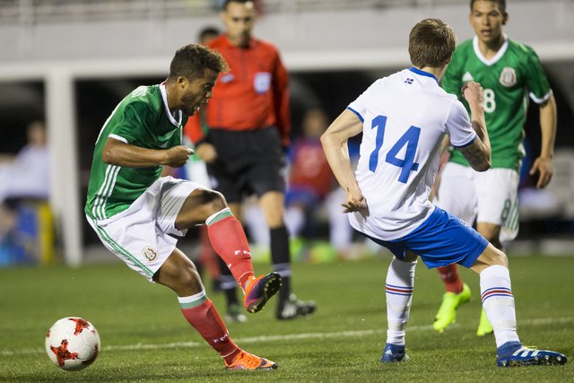 Mexico's Giovani Dos Santos (10) makes a pass under pressure from Iceland's Bodvar Bodvarsson (14) in the men's soccer exhibition match at Sam Boyd Stadium on Wednesday, Feb. 8, 2017, in Las Vegas ...