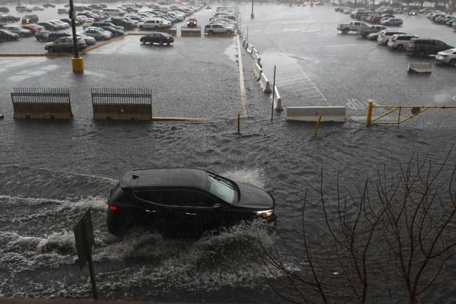 People navigate a flooded parking lot at UNLV in Las Vegas on Saturday, Feb. 18, 2017. (Chase Stevens/Las Vegas Review-Journal) @csstevensphoto
