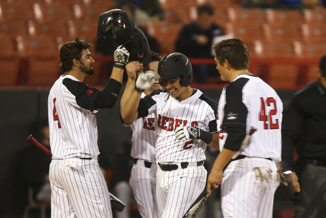 UNLV's infielder Justin Jones (2) celebrates with teammates after hitting a home run with two players on base during their opening season baseball game at Earl E. Wilson Stadium at UNLV in Las Veg ...