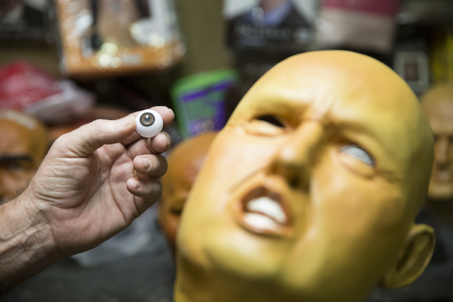 Olaf Stanton, owner of Characters Unlimited, holds an eyeball next to an unfinished character bearing the likeness of President Donald Trump at the Characters Unlimited workshop on Thursday, Feb. ...