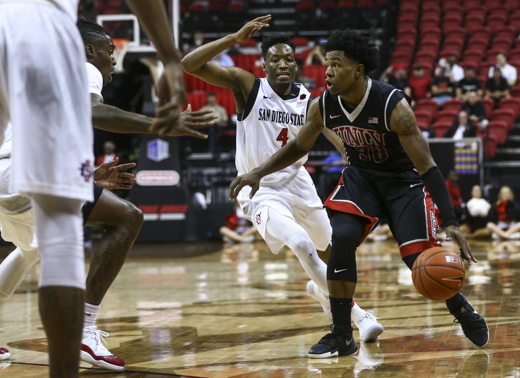 UNLV guard Jovan Mooring (30) drives past San Diego State guard Dakarai Allen (4) during a Mountain West Conference tournament basketball game at the Thomas & Mack Center in Las Vegas on Wedne ...