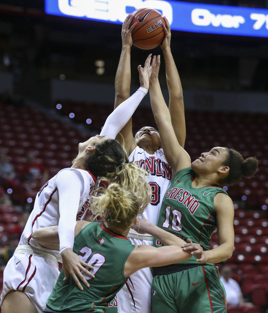 UNLV forward Paris Strawther (3) pulls in a rebound over Fresno State guard Candice White (10) and Fresno State guard Emilie Volk (20) during the Mountain West Conference basketball tournament at  ...