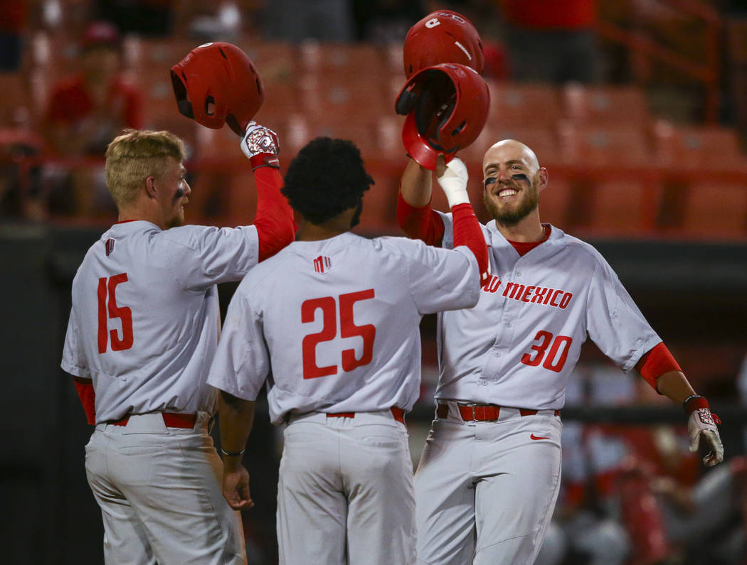 New Mexico infielder Carl Stajduhar (30) celebrates his home run against UNLV with outfielders Andre Vigil (25) and Jared Mang (15) during a baseball game at Wilson Stadium in Las Vegas on Friday, ...