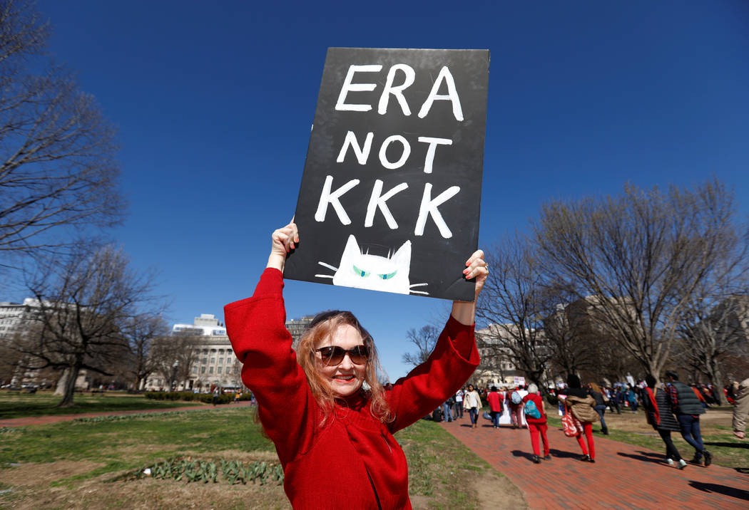 A protester holds a sign aloft as she and hundreds of other activists demonstrate outside the White House as part of "A Day Without a Woman" strike on International Women's Day in Washington, U.S. ...