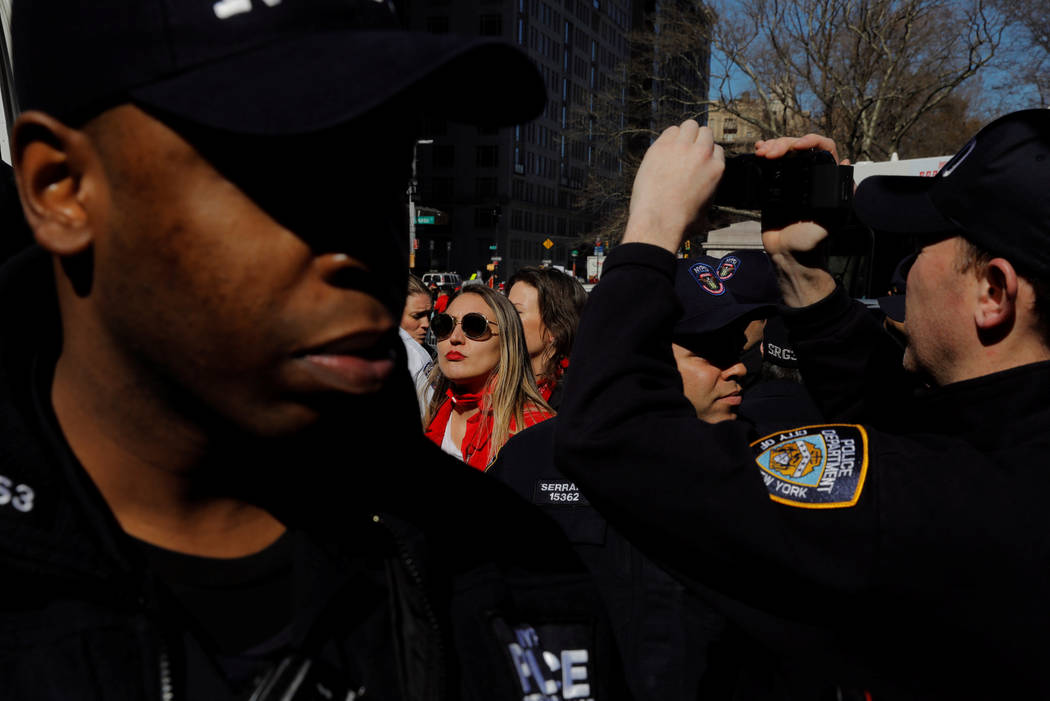 New York Police Department officers arrest a woman in front of Trump International Hotel that was taking part in a 'Day Without a Woman' march on International Women's Day in New York, U.S., March ...