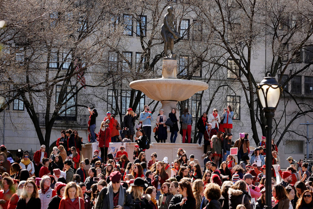 Demonstrators stand on a fountain as they take part in a 'Day Without a Woman' march on International Women's Day in New York, U.S., March 8, 2017. (Lucas Jackson/Reuters)