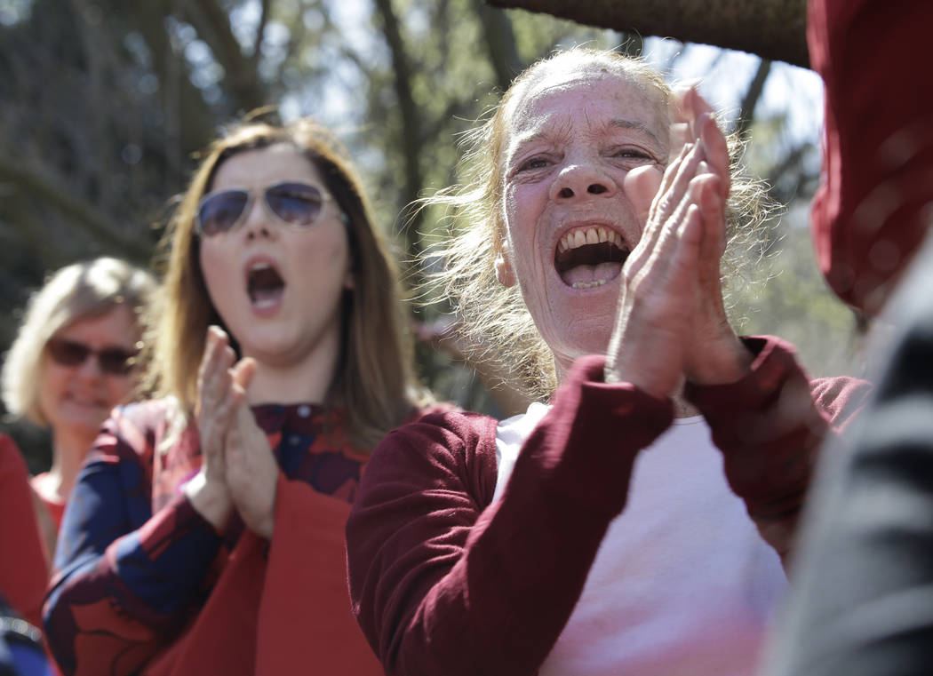 Wearing red, Kimberley Hayes, right, joined others at a Women's Day rally at the Capitol, Wednesday, March 8, 2017, in Sacramento, Calif. The rally was part of the Day Without a Woman action where ...