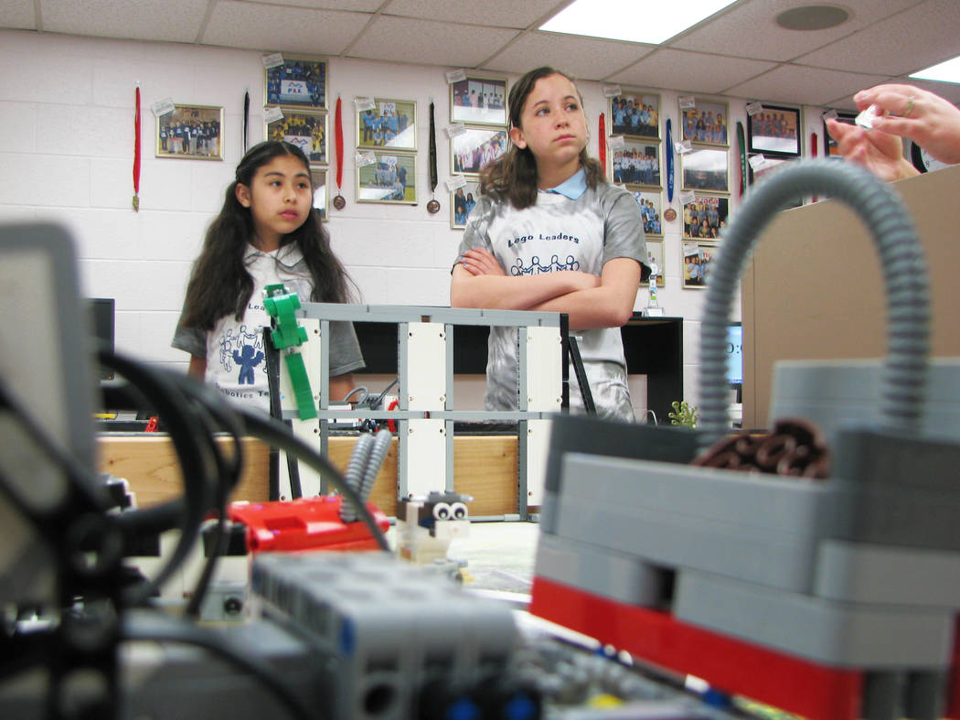 Esmirna Anguiano and Caitlin McKoy of Jo Mackey Academy of Leadership and Global Communication through Technology Lego Leaders team listen to Coach Rachel Kuntz strategize on how to excel at First ...