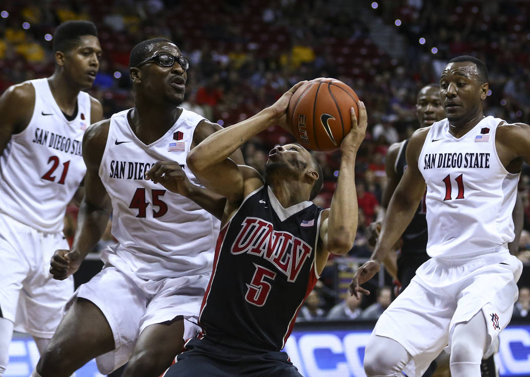 UNLV guard Jalen Poyser (5) drives to the basket against San Diego State center Valentine Izundu (45) during a Mountain West Conference tournament basketball game at the Thomas & Mack Center i ...