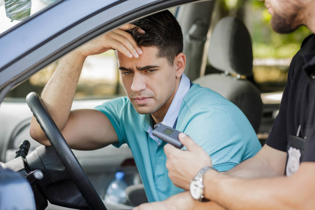 Drunk man caught in car by police officer (Thinkstock)