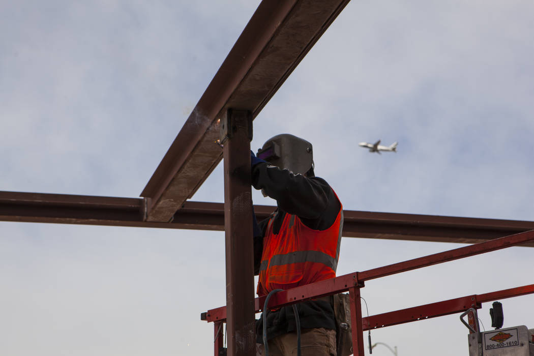 A construction worker welds support beams while working on the new 6-story hotel for the United Brotherhood of Carpenters union's training campus near McCarran International Airport in Las Vegas o ...