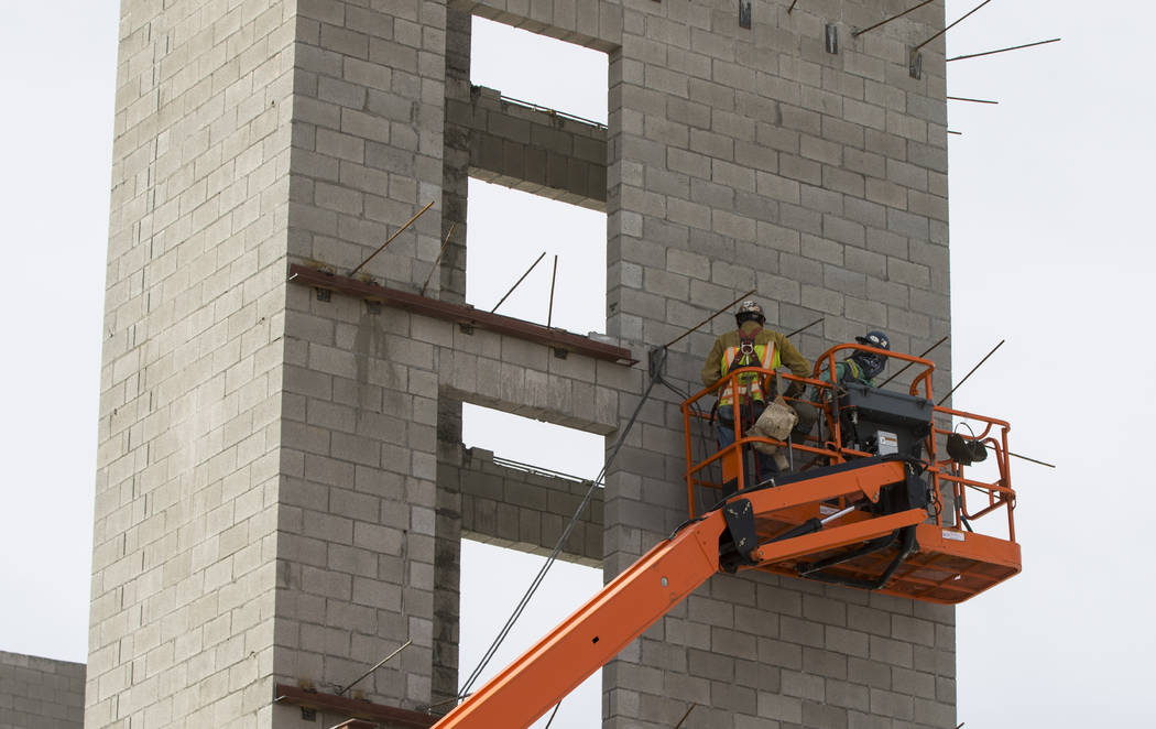 Construction workers use a forklift while working on the new 6-story hotel for the United Brotherhood of Carpenters union's training campus near McCarran International Airport in Las Vegas on Frid ...