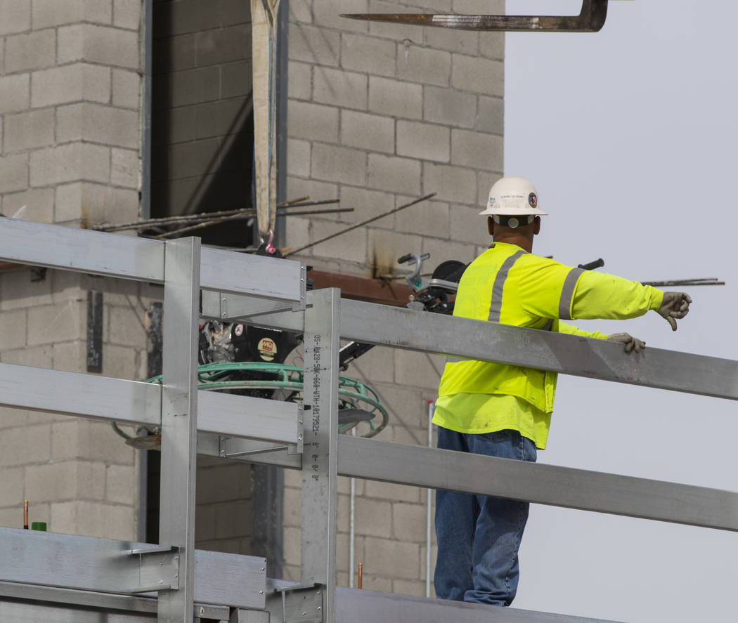 A construction worker helps direct some equipment onto the roof of the new 6-story hotel for the United Brotherhood of Carpenters union's training campus near McCarran International Airport in Las ...