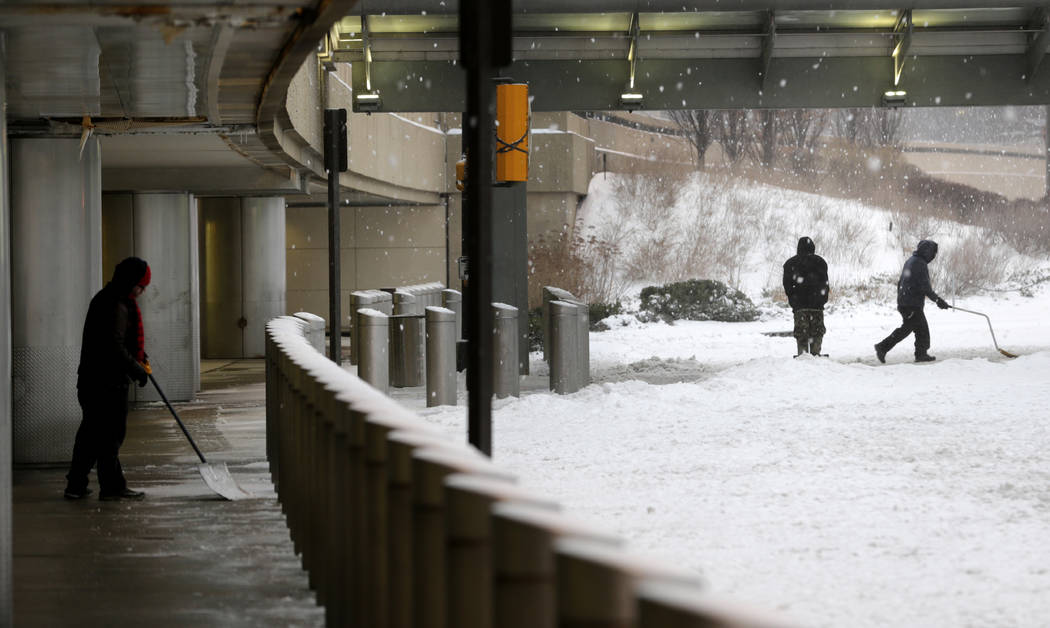 People shovel snow at Newark Liberty International Airport in Newark, N.J., Tuesday, March 14, 2017. A storm pounded the Northeast with more than a foot of snow in places Tuesday, paralyzing much ...