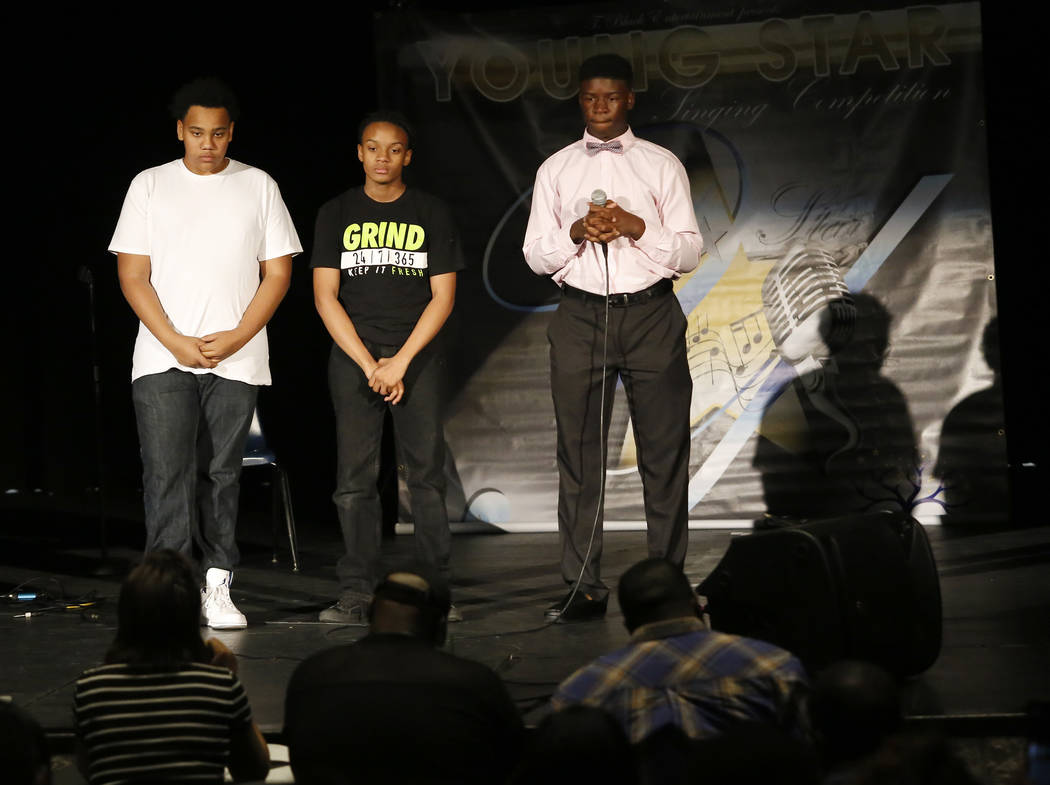 Hosts Dezmone Black, 15, from left, and Jesurun Black, 14, stands next to Jamir Coffee, 15, after Coffee performed in the Young Star singing competition at Cheyenne High School on Saturday, March ...