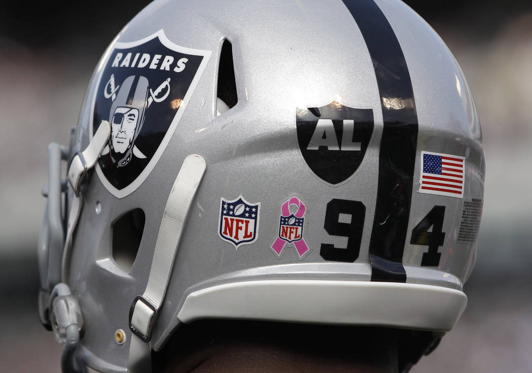 A logo for recently passed Oakland Raiders owner Al Davis is shown on the helmet of defensive end Jarvis Moss (94)  in the fourth quarter of an NFL football game against the Cleveland Browns in Oa ...