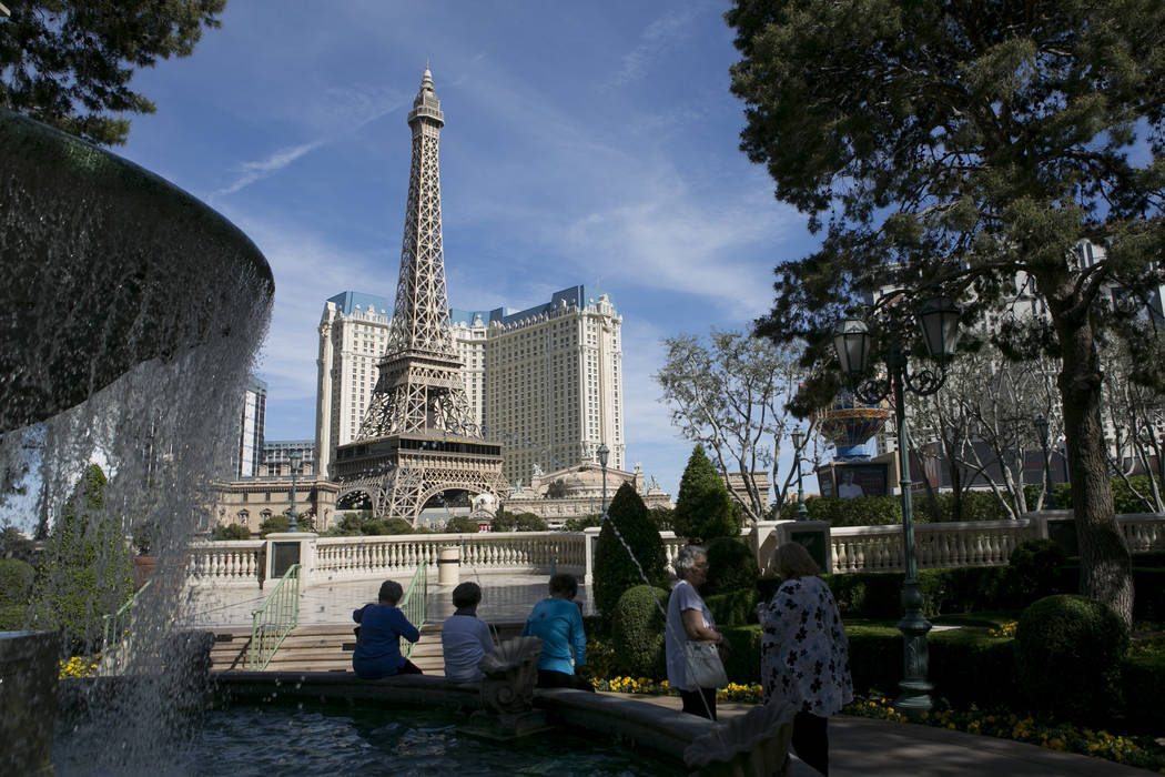 Visitors sit outside Bellagio hotel-casino looking off to the the Fountains of Bellagio and Paris Las Vegas' Eiffel Tower Experience on the Las Vegas Strip on Friday, March 17, 2017, in Las Vegas. ...