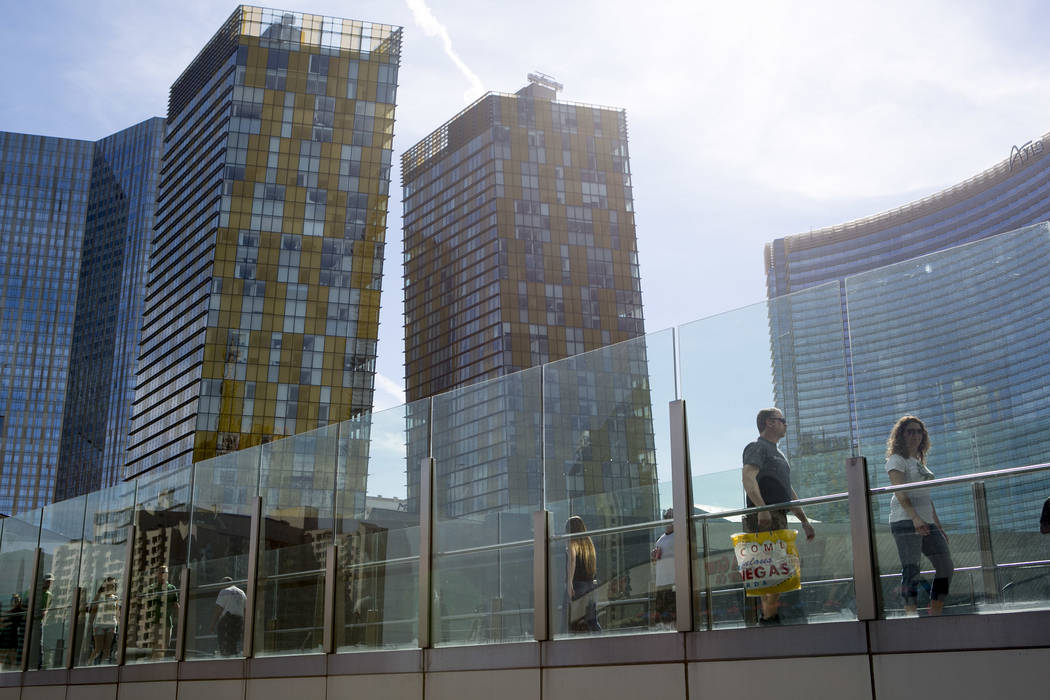 Pedestrians pass the Aria hotel-casino on a walkway over West Harmon Avenue on the Las Vegas Strip on Friday, March 17, 2017, in Las Vegas. (Bridget Bennett/Las Vegas Review-Journal) @bridgetkb